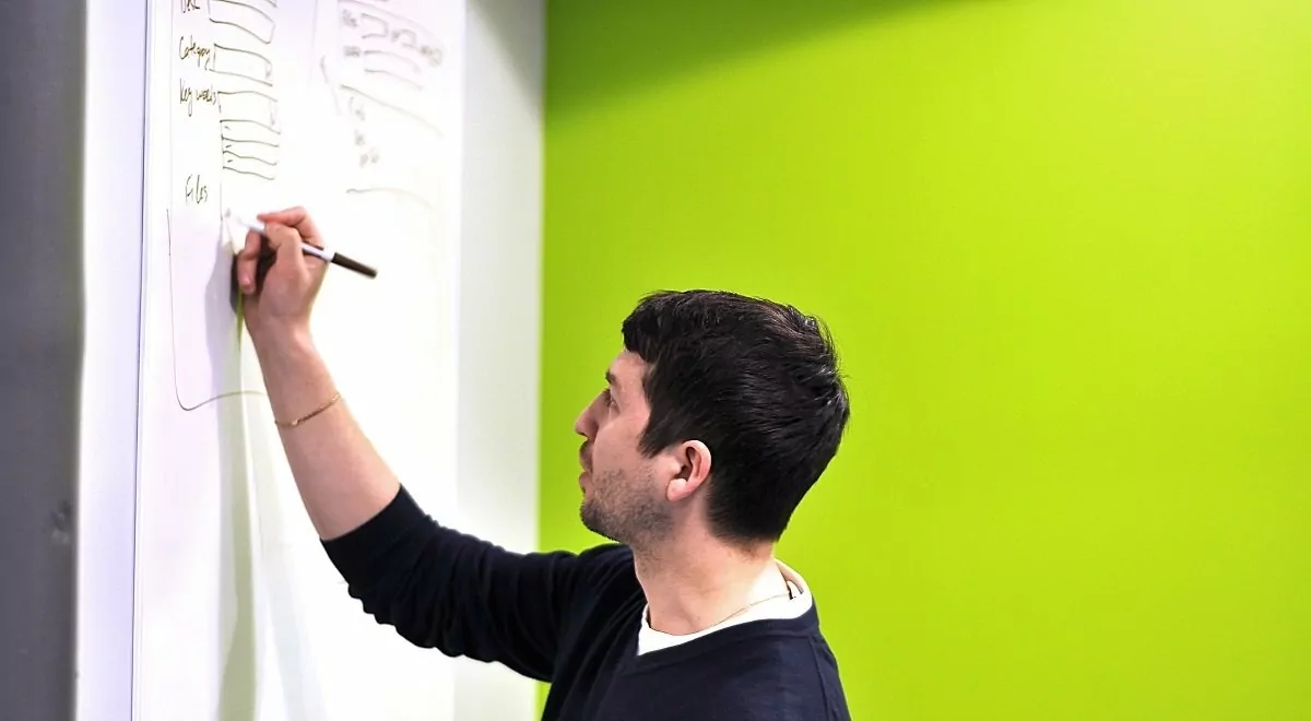 man writing on a whiteboard about the latest development in digital marketing